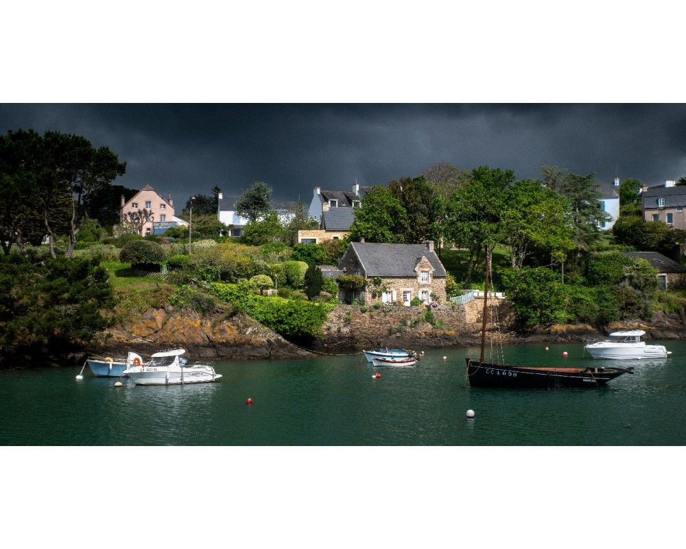 Maisons de Doëlan et barques sous un ciel menaçant