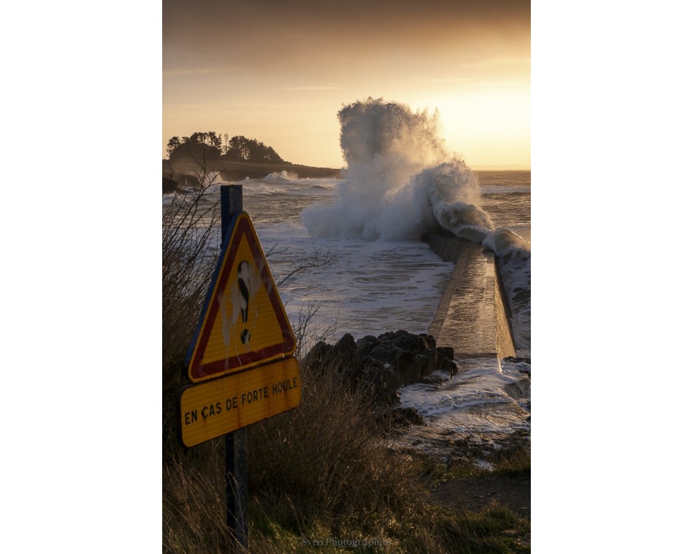 Tempête Floriane, panneau de danger et vague au soleil couchant