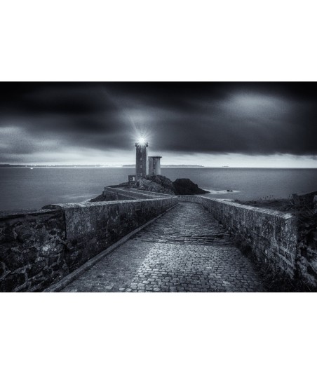 Phare du Petit Minou allumé sous un ciel d'orage — noir et blanc