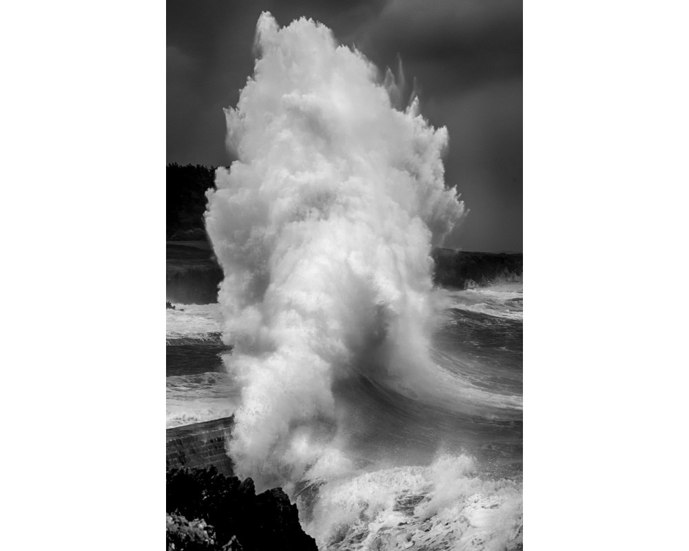 Vague sur la digue de Doëlan — gerbe d'écume en noir et blanc