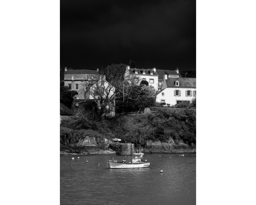 Doëlan en noir et blanc — maisons sur le coteau et barque au mouillage