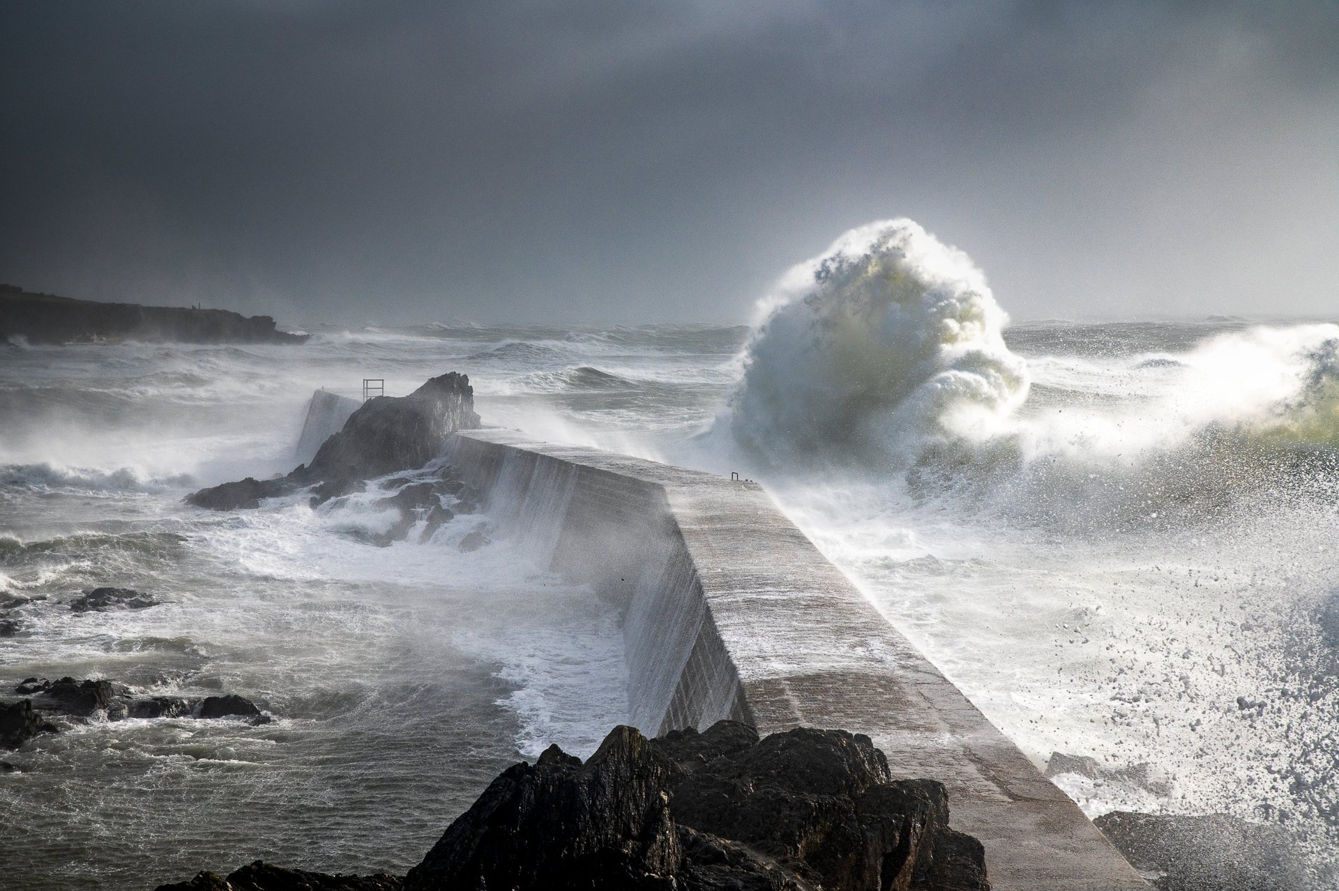 Vague de tempête qui déferle sur une jetée