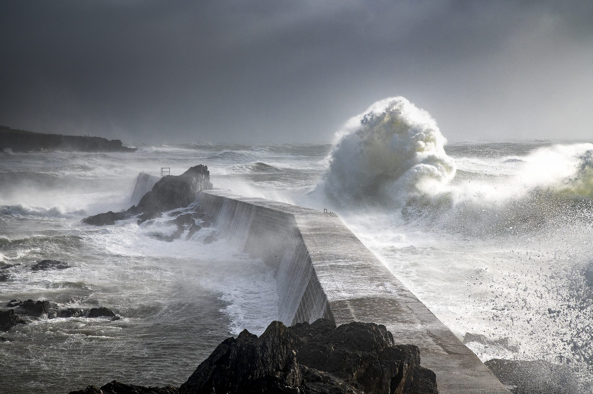 Vague de tempête qui déferle sur une jetée